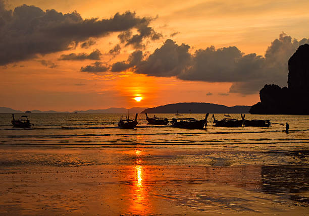 istock Silhouette Longtail Boats On Sea Against Sky During Sunset 636704317