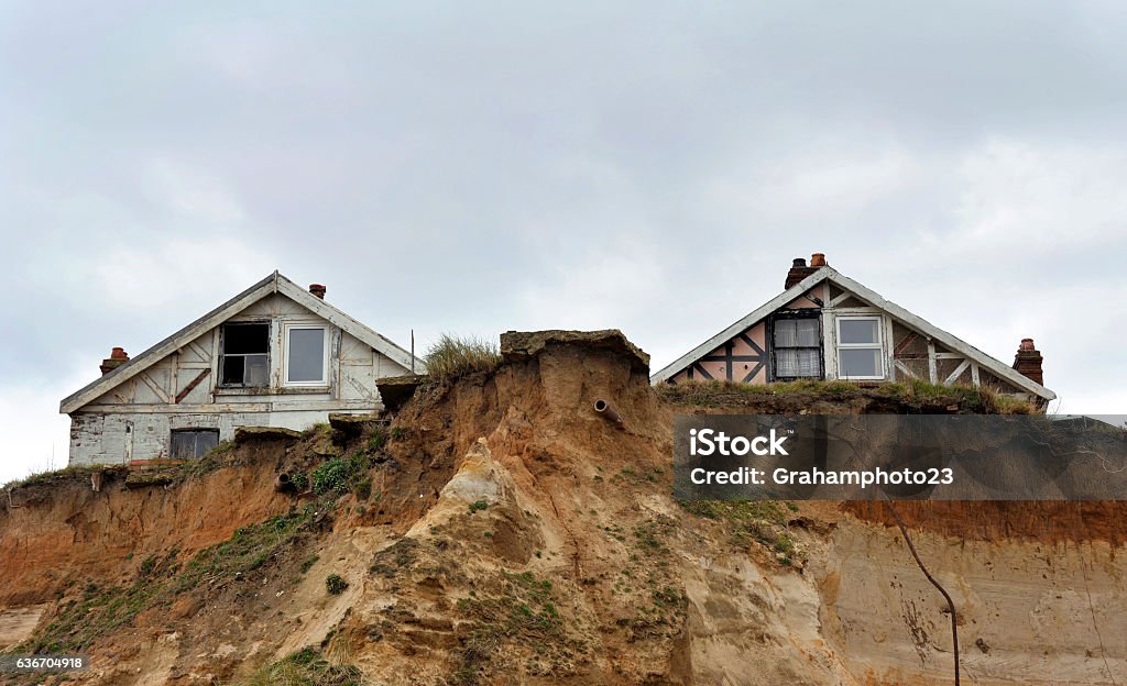 Erosion Homes in danger on the cliff edge at Happisburgh in Norfolk demonstrating levels of erosion along the East Coast. UK. Coastline Stock Photo