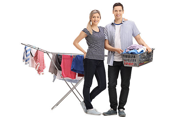 glückliches junges paar vor einem kleiderständertrockner - laundry husband housework men stock-fotos und bilder