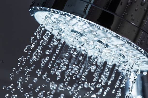 Shower Shower Head with Water Stream on Black Background water conservation photos stock pictures, royalty-free photos & images