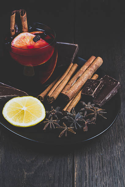 Mulled wine and ingredients on a dark wooden table