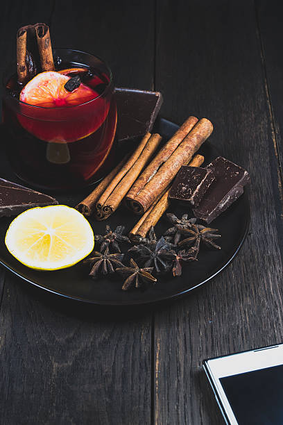 Mulled wine and ingredients on a dark wooden table