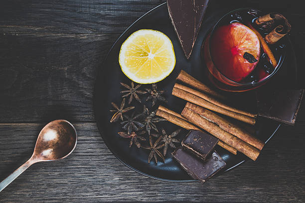 Mulled wine and ingredients on a dark wooden table