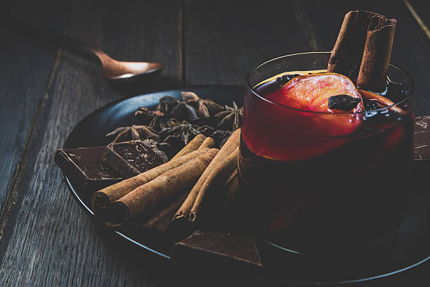 Mulled wine and ingredients on a dark wooden table