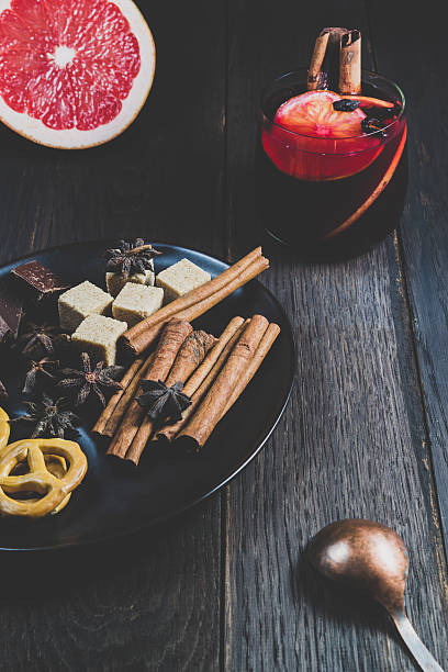 Mulled wine and ingredients on a dark wooden table