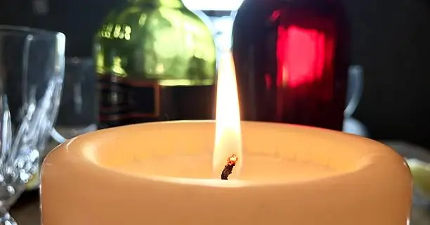 This is a closeup of a candle on a dinner table with wine bottles, wine glasses etc in the background. Taken on Christmas Day, 25th December 2016 in my home in Ireland, Galway. 