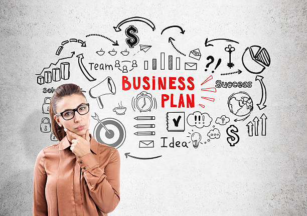 istock Thinking woman in glasses and business plan 636715920