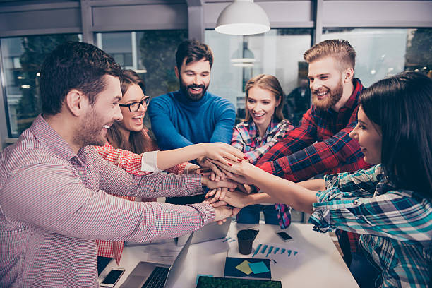 istock Happy businesspeople putting hands on top of hands 636720352
