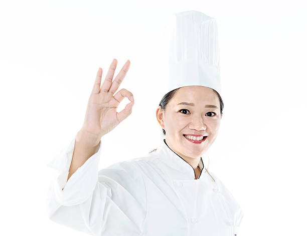 istock Young female chef making OK hand gesture 636721484