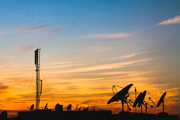 istock Silhouette Satellite Dishes Against Sky During Sunset 636722659