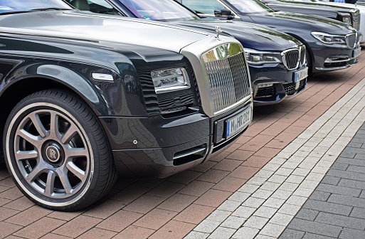 Frankfurt, Germany - September 15th, 2015: Rolls-Royce and BMW vip shuttle cars on the parking. The luxury Phantom model (on the first plan) was debut in 2003 on the market. This limousine from Rolls-Royce is powered by V12 petrol engine (pushing out 453 HP). The Phantom and BMW 7-series (on the second plan) are the ones of the most expensive limousines in the world.