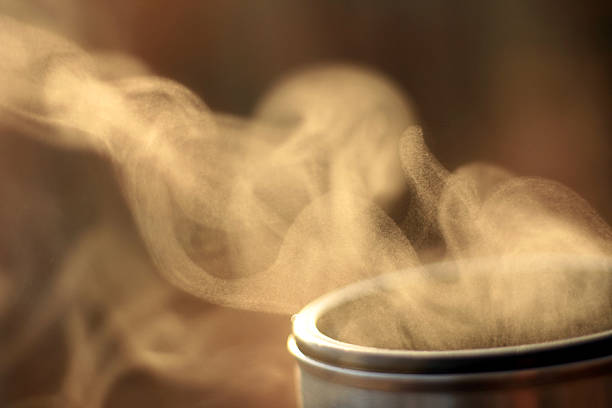 Steam of hot tea against sun in nature, Evaporation