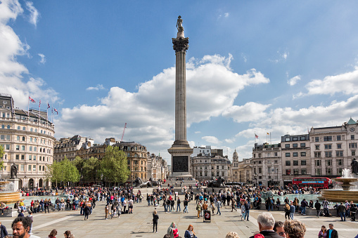 London, UK - May 14, 2016; Trafalgar Square with the statue of Admiral Nelson in the center and people walking around.