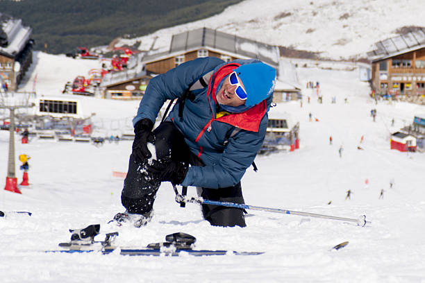 man lying on snow ski crash injured knee in pain stock photo