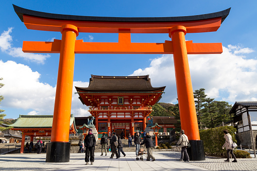 Kyoto, Japan - December 13, 2014: Big orange gate at the Fushimi Inari Shrine and people visiting