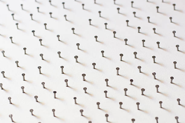 istock Group of Concrete nails Galvanized on white paper back 636734212