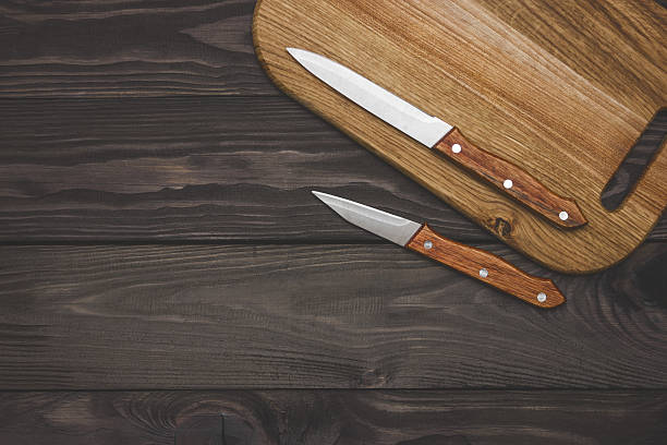 istock cutting board on wooden background with knifes 636736782