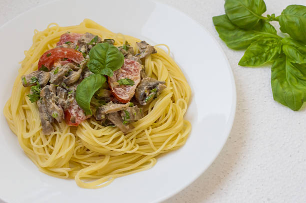 Pappardelle pasta with beef tongue on a white background. Top view. Close-up