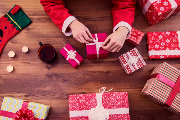 istock Santa Claus with gifts on wooden table 636742014