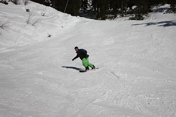 istock snowboarder carving a turn on an alpine piste 636744138