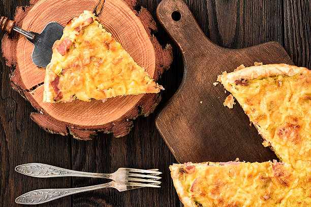 istock Homemade quiche with leek, ham and cheese on wooden background. 636748366
