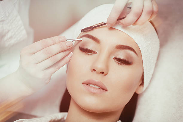 istock Beautiful young woman gets eyebrow correction procedure 636748978