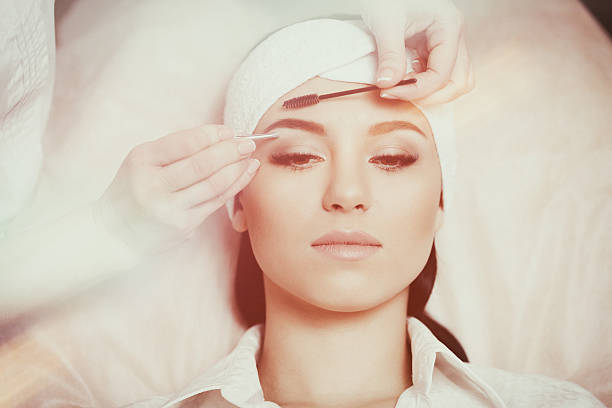 istock Beautiful young woman gets eyebrow correction procedure 636749028