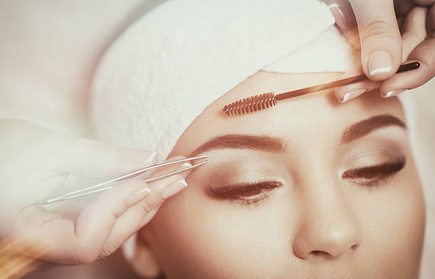 istock Beautiful young woman gets eyebrow correction procedure 636749224