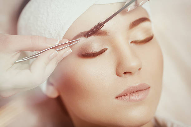istock Beautiful young woman gets eyebrow correction procedure 636749258