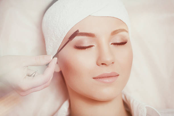 istock Beautiful young woman gets eyebrow correction procedure 636749318