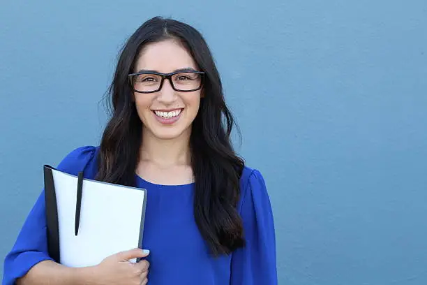 Young business woman with eyeglasses isolated on blue background.