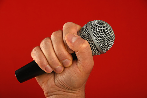 Wireless microphone with santa hat on it closeup on red background