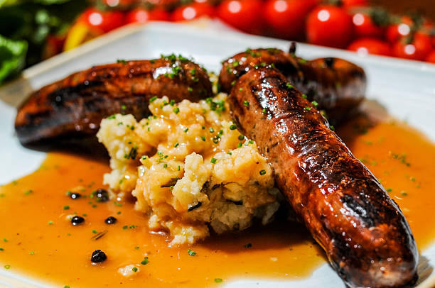 salsiccia di cumberland e poltiglia con sugo - sausage food mash grilled foto e immagini stock