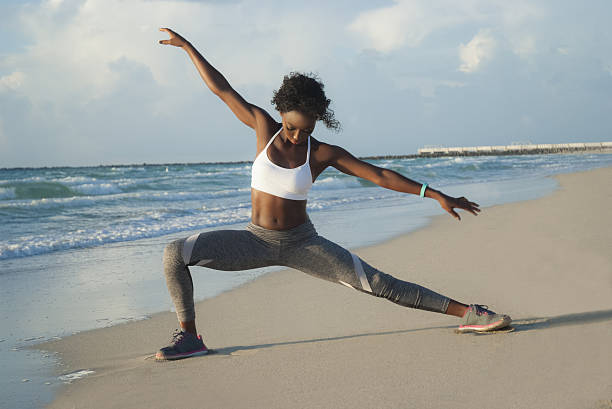 istock Young woman stretching on beach 636758848