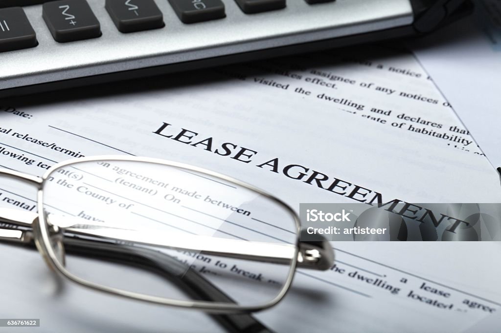 Business Lease Agreement Documents with Glasses, Pen and Calculator Lease Agreement Stock Photo