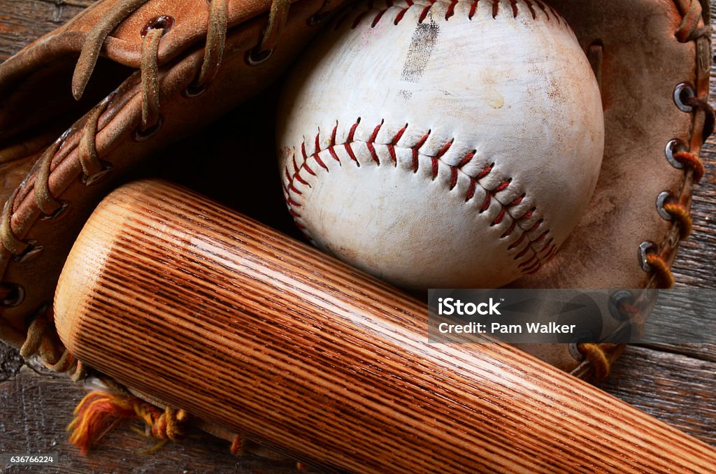 Old Baseball Equipment A top view image of an old used baseball, baseball glove, and wooden bat. Softball - Ball Stock Photo