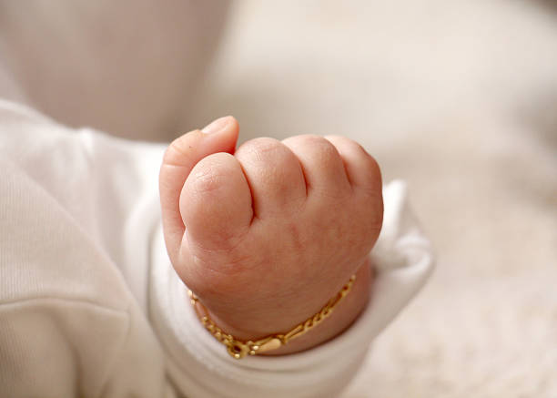 hand of a baby and gold bracelet - hand gold jewels bildbanksfoton och bilder