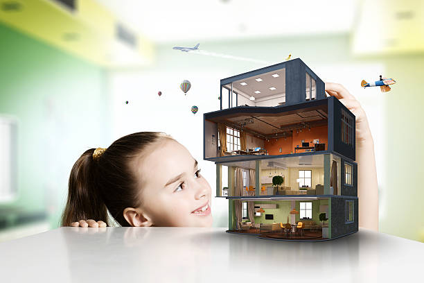 Design of your dream house . Mixed media Cute girl looking at model of house on table . Mixed media model house stock pictures, royalty-free photos & images