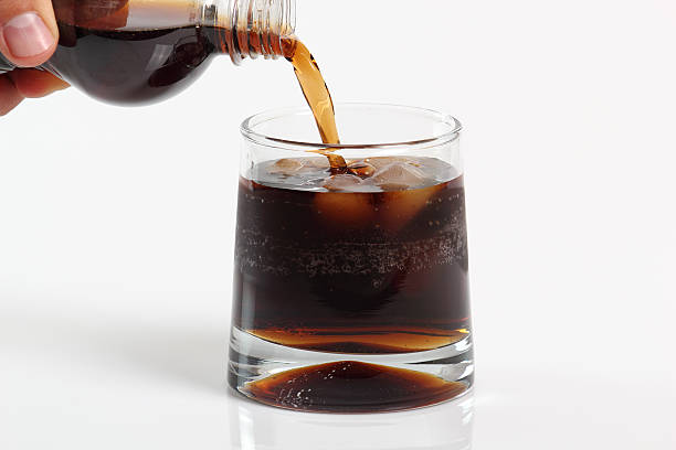 istock Pouring cola from plastic bottle into glass with ice cubes 636776080