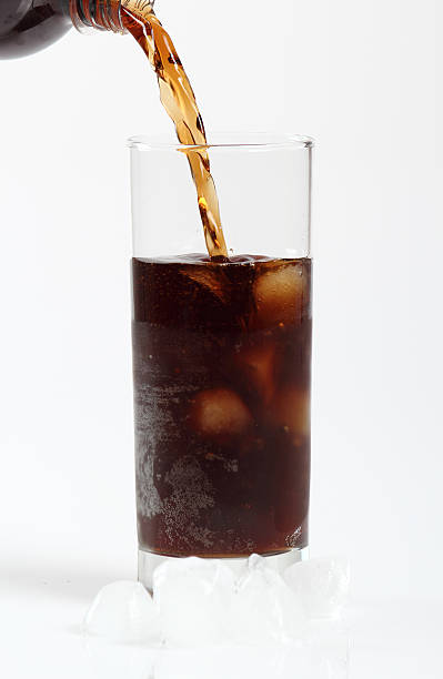 istock Pouring cola from plastic bottle into glass with ice cubes 636776110