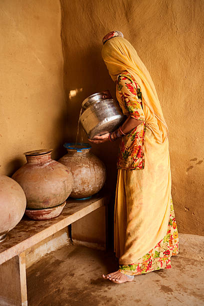 istock Indian woman carrying water from well. 636777596