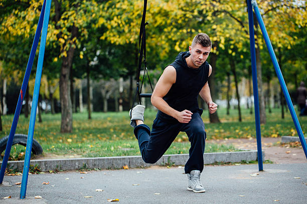 istock TRX training. Man Instructor at the park doing Excersise. Fitness 636778966
