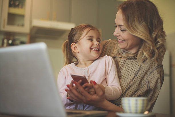 istock Mother with daughter using mobile phone. 636780028