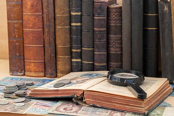 istock The old coins, banknotes, magnifying glass and open antiquarian book. 636781164