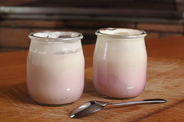 istock Yogurt in open small glass jar with spoon 636782520