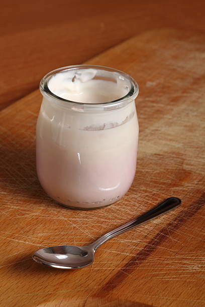 istock Yogurt in open small glass jar with spoon 636782566