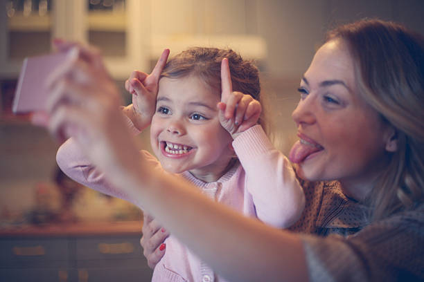 Mother with daughter making funny face. Little girl making self portrait with her mom. making a face photos stock pictures, royalty-free photos & images