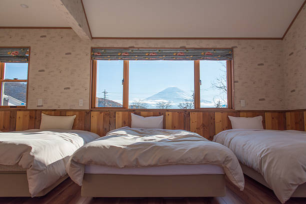 Bed with MT.Fuji view as background outside the window. Bed with MT.Fuji view as background outside the window in winter season of Kawaguchiko, Japan. lake kawaguchi stock pictures, royalty-free photos & images