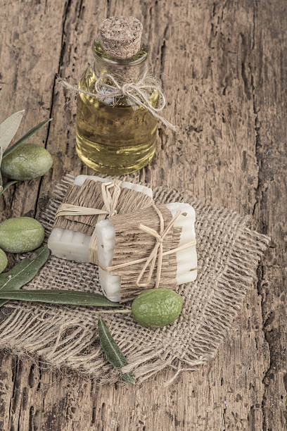 istock Olive oil soap bar and oil bottle on wooden table 636788310