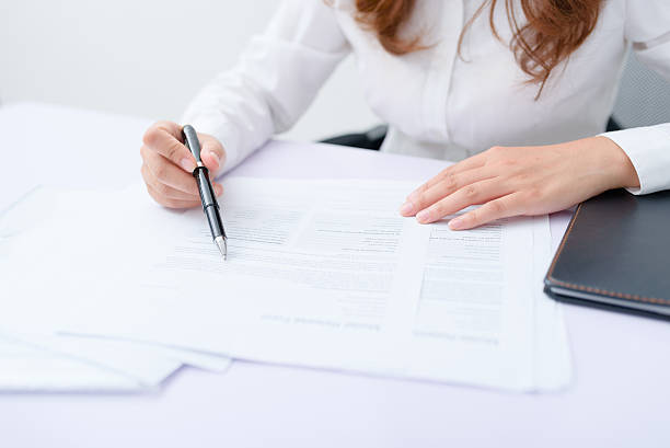 istock Business woman filling information on document. 636789758